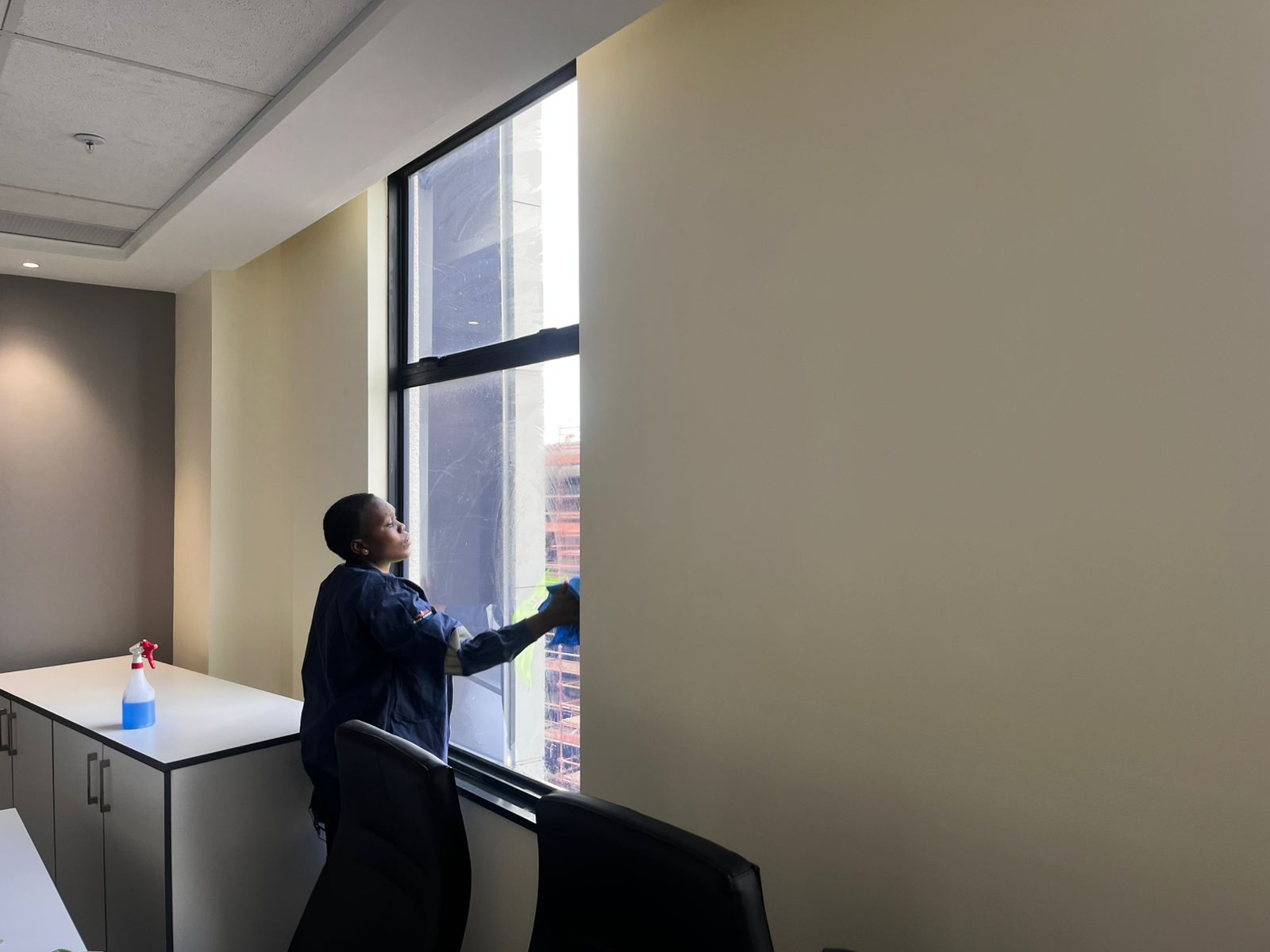 Cleaning large window overlooking parking area